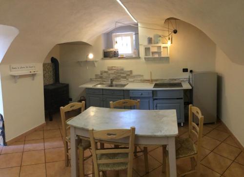 a kitchen with a table and chairs in a room at Il Giramondo in Busca