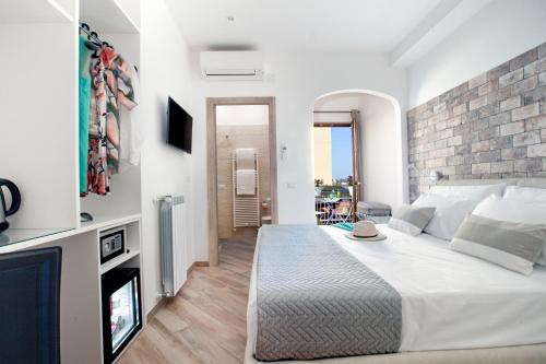 a bedroom with a white bed and a brick wall at Viria B&B Sorrento in Sorrento