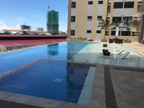 a large swimming pool in a building with chairs at The Persimmon Studios Near Ayala and SM City Cebu in Cebu City
