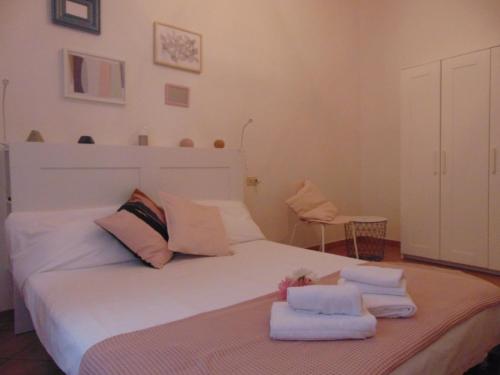 a bedroom with a white bed with towels on it at Gessi Charming Apartments in Florence