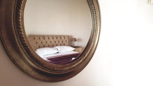a mirror reflecting a bed in a bedroom at Arianna in Paleokastritsa