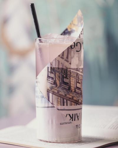 a glass filled with a dollar bill with a straw at Hotel St. George Helsinki in Helsinki