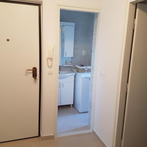 a white kitchen with a sink and a door at Apartment LANA Kaštel Stari in Kaštela