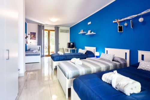 a room with three beds and a blue wall at Rocca degli Etnei in Paterno
