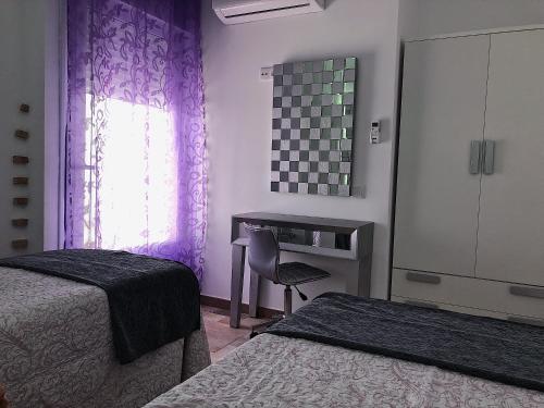 a bedroom with two beds and a desk and a window at Retiro del Teatro Almagro in Almagro