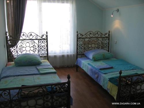 two beds sitting in a room with a window at Sauvignon-Zagara in Odesa