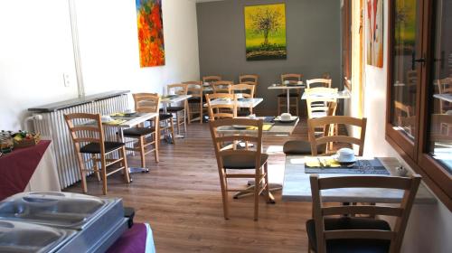 una fila de mesas y sillas en un restaurante en Hotel des Alpes, en Die