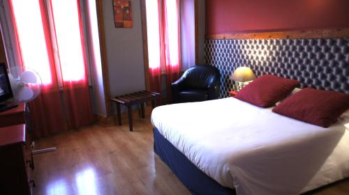 a hotel room with a bed and a chair at Hotel des Alpes in Die