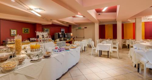 a restaurant with white tables and white chairs at Art & Hotel Aeroporto in Stezzano