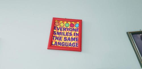 a sign on a wall with the words everyone smiles in the same language at Hostel City Center in Chişinău