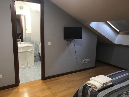 1 dormitorio con cama y baño con espejo. en Apartamento Good Way, en O Pedrouzo