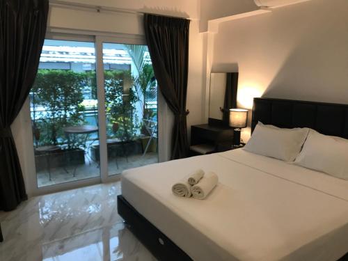 een slaapkamer met een bed met twee handdoeken erop bij Cafe de Paris in Patong Beach