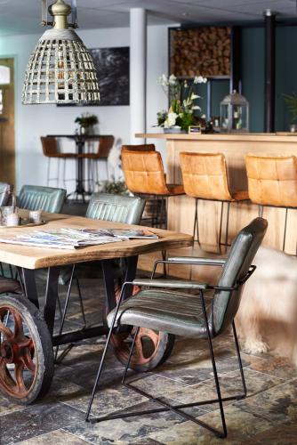 a table and chairs in a restaurant with a table and chairs at Hotel-restaurant "Lely" in Oude-Tonge