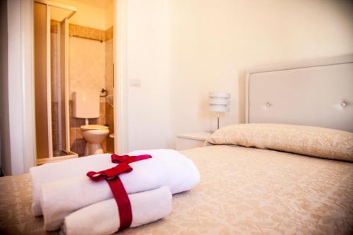 - une chambre avec un lit doté d'un ruban rouge dans l'établissement Sardinian Gallery Temo, à Bosa