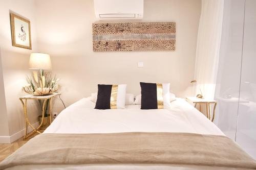 セビリアにあるPajaritos Palace by Valcambreのベッドルーム1室(白い大型ベッド1台、サイドテーブル2台付)