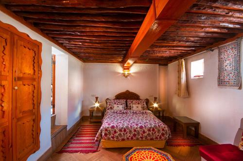 a bedroom with a bed and a wooden ceiling at Riad Dar Jabador in Sale