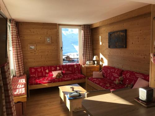 a living room with red couches and a window at Prariond 5 in Tignes