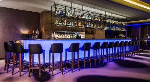 a bar with black stools and a blue counter at Airport Hotel Okęcie in Warsaw