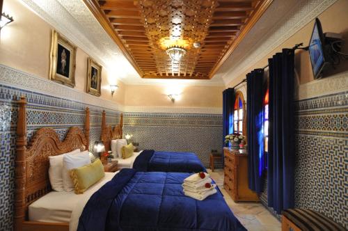 a bedroom with two beds and a couch in it at Dar Al Madina Al Kadima in Fès