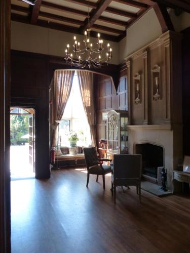 a living room with a chandelier and a fireplace at Farnham House Hotel in Farnham