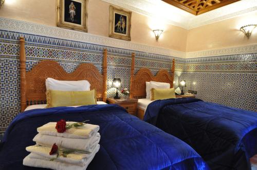 a bedroom with two beds with towels on them at Dar Al Madina Al Kadima in Fès