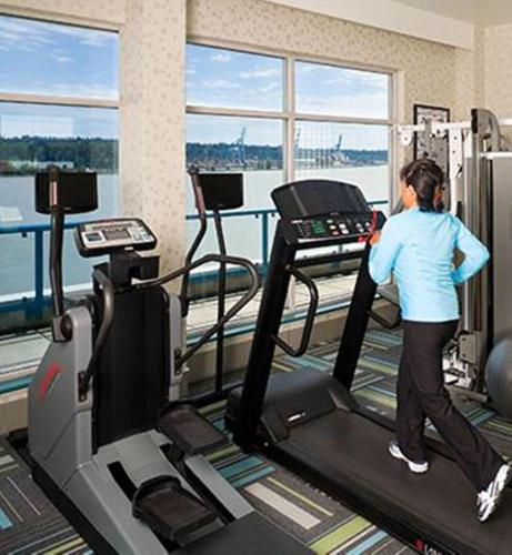 a woman walking on a treadmill in a gym at Inn At The Quay in New Westminster