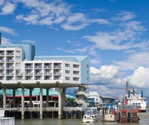 a building on the water next to a river at Inn At The Quay in New Westminster