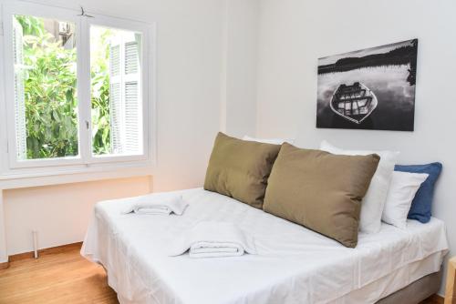 Warm Apartment at Exarchia 1 bed 2 pers في أثينا: سرير أبيض في غرفة بها نافذة