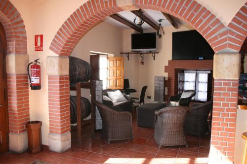 ein Wohnzimmer mit einem Torbogen mit Stühlen und einem Kamin in der Unterkunft Trisileja en Posada La Busta in La Busta