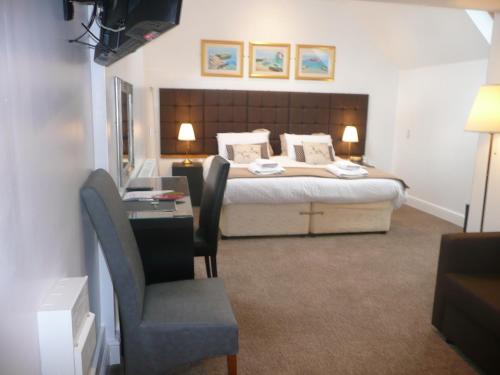 a bedroom with a bed with a desk and a chair at Noble Lands in Wooler