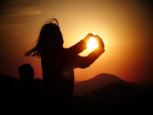 a silhouette of a woman holding the sun at sunset at Venkovské apartmány Tiché pastviny in Stein Schönau
