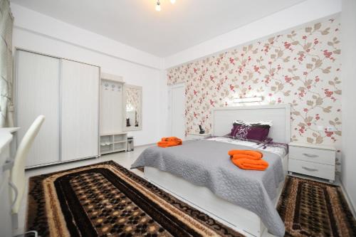 a bedroom with a bed with orange towels on it at Trident in Haţeg