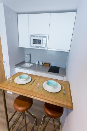 a small kitchen with a table with two plates on it at Casa de la Merced Suites in Málaga