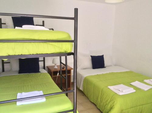 two bunk beds in a room with green sheets at Alojamento Local Duarte's in Coimbra
