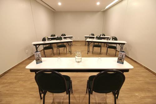 an empty room with tables and chairs in it at Impar Suites Barao de Cocais in Barão de Cocais
