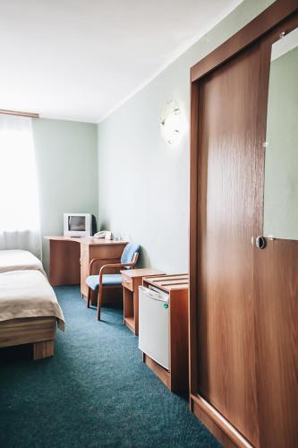 a hotel room with a bed and a wooden door at Nikotel Hotel Mykolaiv in Mykolaiv
