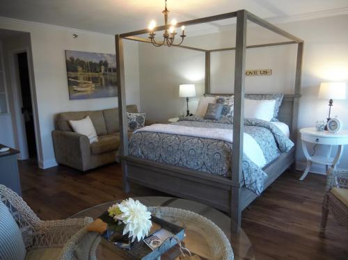 a bedroom with a canopy bed and a living room at Harbor House Inn in Sackets Harbor