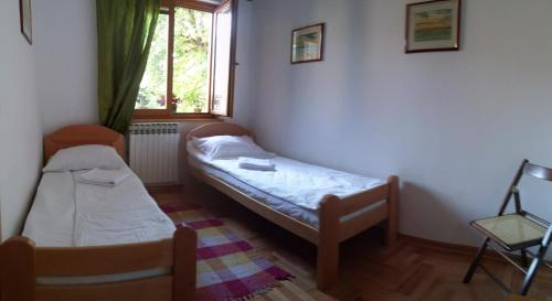 a small room with two beds and a window at ABAGuesthouse in Sarajevo