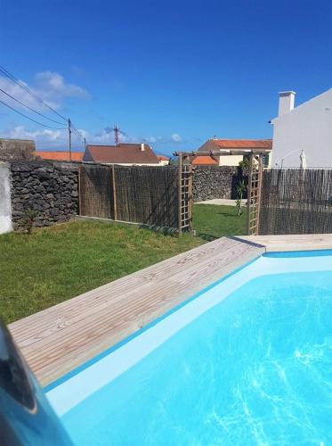 a swimming pool in a yard with a fence at Refúgio in Horta
