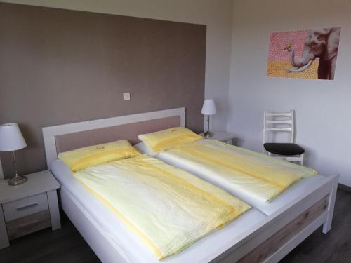 1 Schlafzimmer mit 2 Betten und gelber Bettwäsche in der Unterkunft Ferienwohnung Westfalenblick in Goldhausen