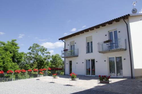 a white building with flowers in front of it at La Casa Di Alice in Rodello