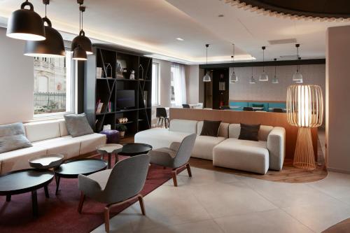 a living room with a couch and chairs and tables at Novotel Suites Colmar Centre in Colmar