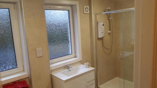 a bathroom with a sink and a shower at Newtown Apartments in Boʼness