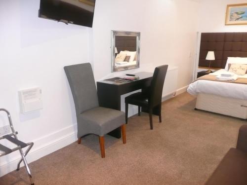 a room with a desk and a bed and a bedroom at Noble Lands in Wooler