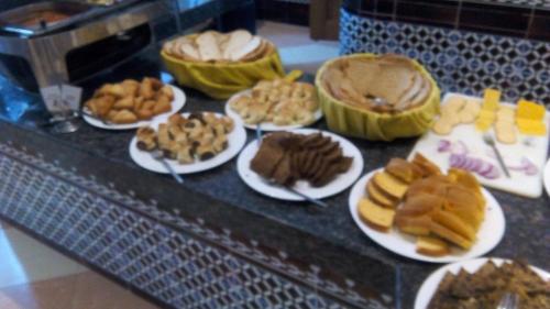 a table with plates of food on plates with desserts at Royal Court Hotel in Mombasa
