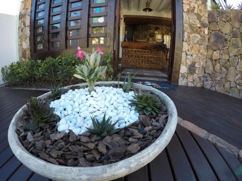 a large stone planter with plants in it on a deck at Pousada Do Capitão in Arraial do Cabo