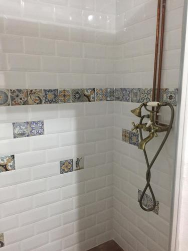 een badkamer met een douche met tegels aan de muur bij Casa Bunicilor in Sibiel