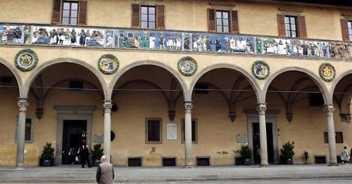 a man walking in front of a building with mosaics at B&B Il Grifone in Pistoia