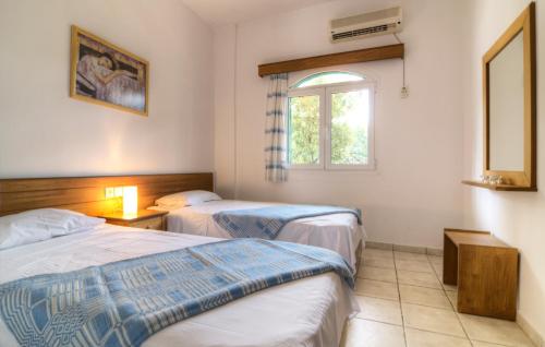 a hotel room with two beds and a window at Elia & Tina Apartments in Hersonissos