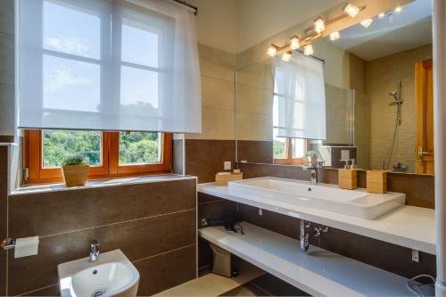 a bathroom with a sink and a toilet and a window at Villa Sveti Jakov in Sveti Jakov